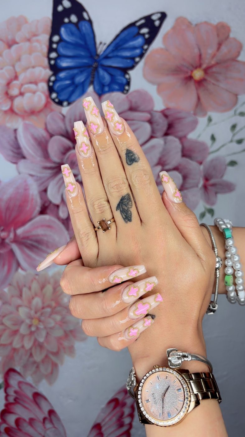 Nude coffin nails with pink clover motifs and gold bead detail